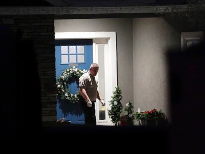 Un oficial de la policía sale de la residencia donde fueron encontrados los ocho cuerpos de una familia en Enoch, Utah.