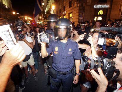 Un policía filma a manifestantes de la marcha "contra la brutalidad policial", ayer en la calle de Atocha.
