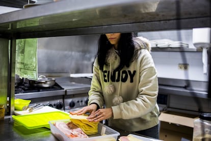 Una trabajadora en una local de hostelería en Vilanova de Arousa (Galicia) prepara una bocadillo en enero de 2024.