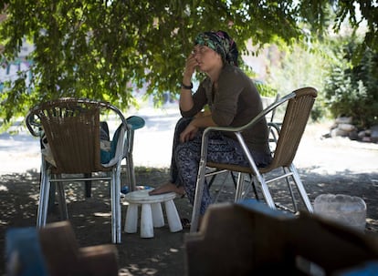 Sebidang espera sentada a que Virgul, su suegra, termine de enjuagar los cubiertos para poder almorzar bajo los pinos del parque.