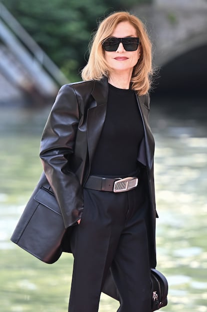 Huppert once recounted that for most of her life she didn't care much about style rules. However, she is fully aware that “The public's perception of a character can change drastically (and irrevocably) with the elevation of a stiletto heel or a smudge of red lipstick.” Here, descending from her “water cab,” in an outfit of blazer and slacks, all in black. 