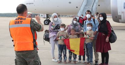 Un grupo de afganos ante un avión procedente de Dubái con evacuados desde Afganistán a su llegada este miércoles a la Base Aérea de Torrejón de Ardoz (Madrid), el 27 de agosto.