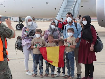 Un grupo de afganos ante un avión procedente de Dubái con evacuados desde Afganistán a su llegada este miércoles a la Base Aérea de Torrejón de Ardoz (Madrid), el 27 de agosto.