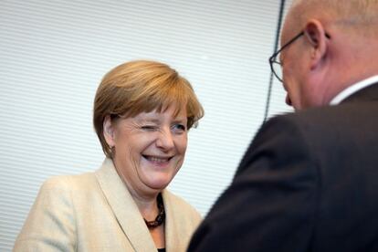 La canciller Angela Merkel sonríe al jefe del grupo parlamentario de la CDU, Volker Kauder, antes de la reunión de su grupo parlamentario.