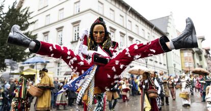 Un Federahannes, un bufón de Rottweil, salta sobre un palo durante el tradicional desfile 'Rottweiler Narrensprung', celebrado durante las fiestas de carnaval en Rottweil (Alemania).