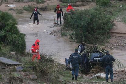 Guardias civiles y bomberos rastrean la zona junto al vehículo del hombre desaparecido.