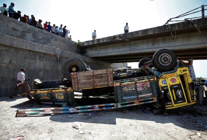 Oficiales de policía inspeccionan un camión, que llevaba invitados a una fiesta de boda, accidentado en el pueblo de Ranghola (India).