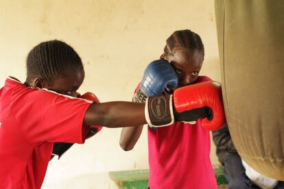 Dos de las benjaminas entrenan con el saco antes de pasar a luchar con Priest, el fundador y entrenador de las Box Girls. A la derecha, Teresa, que con 13 años es campeona de Kenia en su categoría.
