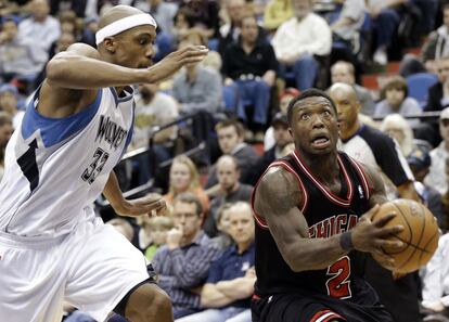 A la derecha, Robinson, de los Bulls, ataca la canasta ante Cunningham, de los Timberwolves.