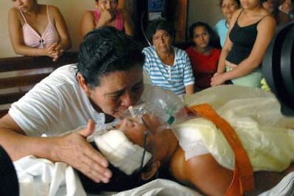 Una mujer llora junto a un paciente en estado crítico, tras la intoxicación masiva.