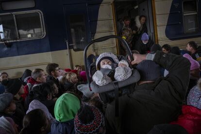 Un hombre lleva a un bebé mientras la multitud intenta subir a un tren a Lviv en la estación de Kiev, Ucrania. Los hombres ucranianos tienen que quedarse para luchar en la guerra mientras las mujeres y los niños abandonan el país. Las tropas rusas continúan su ofensiva en varias de las principales ciudades de Ucrania como la capital, Kiev; Járkov (en el noreste del país) y Mariupol (sureste), pasados nueve días del inicio de la invasión. Este último municipio costero aguanta el asedio de las tropas rusas, aunque la inteligencia británica ha asegurado este viernes en un comunicado que el cerco a la ciudad de casi medio millón de habitantes es cada vez más estrecho.