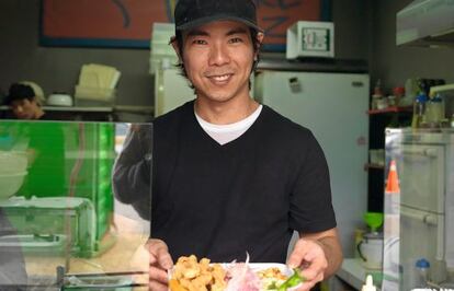 El cocinero Tomás 'Toshi' Matsufuji enseña uno de sus platos en su local Al Toke Pez, un puesto de comida peruana en Lima.