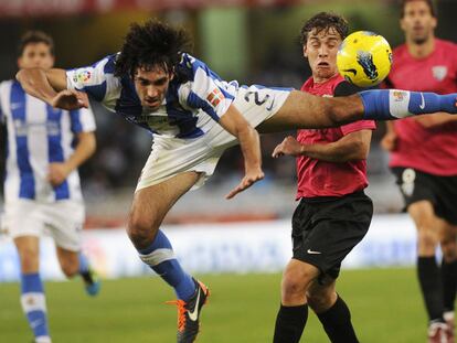Carlos Martínez salta por el balón junto a Seba.