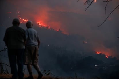 Vecinos observan el incendio en Quiroga (Lugo), el lunes. 