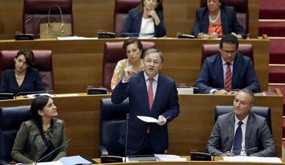 El consejero de Hacienda, Juan Carlos Moragues, durante la sesión de control, observado por Alberto Fabra y María José Català.