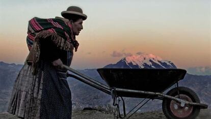 La foto d'una boliviana empenyent un carretó.