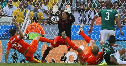 Ochoa detiene un disparo de Huntelaar durante un partido entre México y Holanda en el Mundial de 2014.