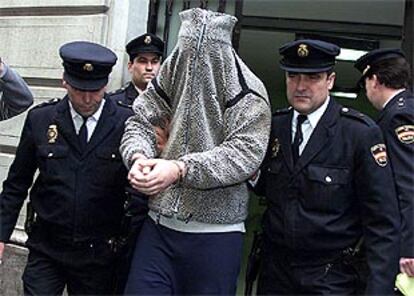 Uno de los tres acusados por el crimen, ayer, al salir de la Jefatura de Policía de Barcelona hacia los juzgados.