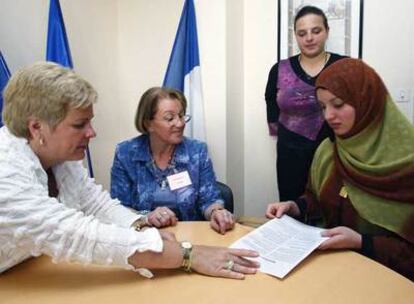 La ex ministra francesa de Cohesión Catherine Vautrin (izquierda) da un contrato de integración en 2005.
