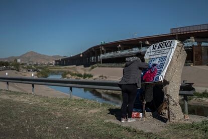 Una mujer descansa junto frente al muro fronterizo que divide Ciudad de Juárez y El Paso, en el Estado de Texas.