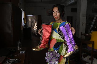 Lariana Lera Guerrero, fundadora e integrante de Deseo Zapatos, sostiene dos botas elaboradas en el taller.