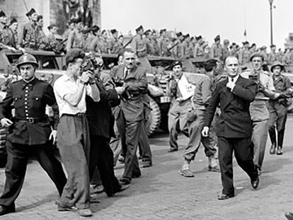 Gilbert Larriaga, a la izquierda, graba con su cámara a Charles De Gaulle en la liberación de París.