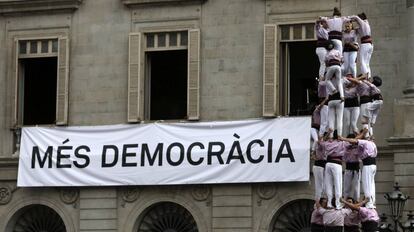 3/09/2017. La colla castellera Minyons de Terrassa levantan una "cuatre de nou amb folre i manilles" ante un cartel que pide "Mas democracia".