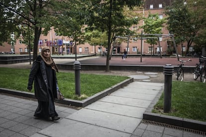 Uma mulher passeia por um dos parques que ligam os diversos blocos do gueto semicerrado de Mjølnerparken, no centro de Copenhague, no qual vivem quase 2.000 pessoas.