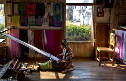 Una mujer padaung (mujeres de cuello de jirafa) teje en una tienda de recuerdos en el poblado de Ywama (Myanmar).