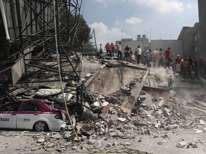 Voluntários fazem busca em um edifício que desmoronou no bairro de Roma.