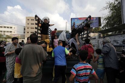 Un grupo de palestinos se sube a un camión intentando huir de Gaza, el 20 de julio de 2014.