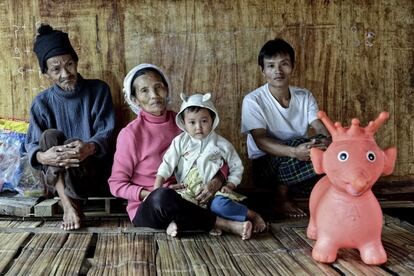 Lahtaw Zansan, a la derecha, posa con sus padres y con uno de sus hijos en la vivienda de bambú que ocupan en el campo de Jeyang. Escaparon aquí en 2013 cuando los combates llegaron a su pueblo.