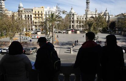 Turista en el balc&oacute;n del Ayuntamiento miran los trabajos de montaje del dispositivo para las &#039;mascletades&#039;.