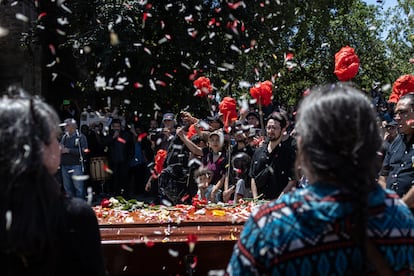 Hijas de Joan Jara realizan un homenaje durante su funeral en la entrada del cementerio general, en Santiago, Chile.