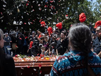 Hijas de Joan Jara realizan un homenaje durante su funeral en la entrada del cementerio general, en Santiago, Chile.