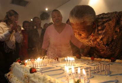 O ex-presidente sul-africano Nelson Mandela assopra as velas de um bolo, junto de seus colaboradores, na véspera de seu aniversário em julho de 2006 em Johannesburgo.