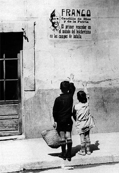 Unos niños, frente a un cartel de Franco tras la Guerra Civil.