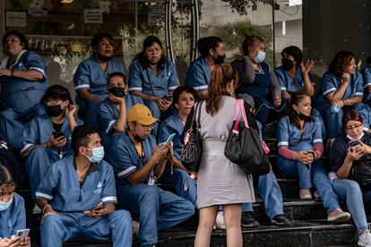 En Balderas, Ciudad de México, trabajadores de la limpieza esperan luego de ser evacuados durante el seísmo.