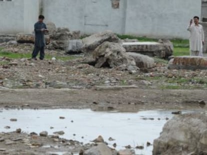 Unos hombres toman fotos de los restos de la casa de Bin Laden, en Abbottabad, demolida hace un mes por las autoridades paquistan&iacute;es.