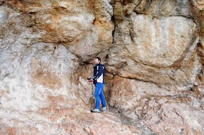 Un arqueólogo observa las pinturas rupestres de la gruta de Los Machos.