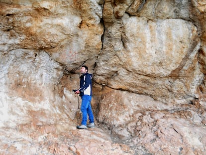 Un arqueólogo observa las pinturas rupestres de la gruta de Los Machos.