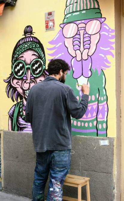 El artista Ramón Amorós dibujando a los 'mandrileños' en la Calle Argumosa.