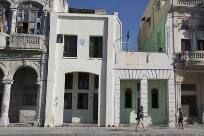 Un turista deambula frente a unas viviendas de alquiler en Cuba.