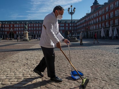 Un camarero barre antes de instalar la terraza en la plaza Mayor de Madrid, el pasado 9 de octubre.