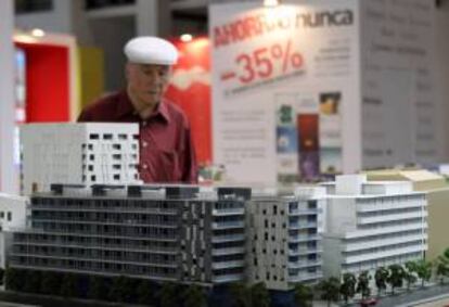 Un visitante observa una maqueta en un stand en un salón inmobiliario. EFE/Archivo