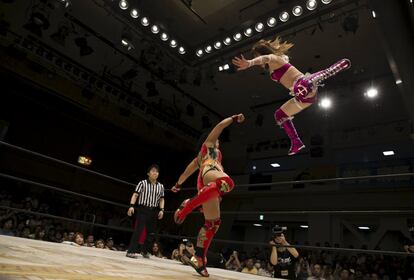 Wrestler Kaori Housako jumps at her opponent Mieko Satomura during a Stardom female professional wrestling show at Korakuen Hall in Tokyo, Japan, July 26, 2015. Professional women's wrestling in Japan means body slams, sweat, and garish costumes. But Japanese rules on hierarchy also come into play, with a culture of deference to veteran fighters. The brutal reality of the ring is masked by a strong fantasy element that feeds its popularity with fans, most of them men. REUTERS/Thomas Peter   TPX IMAGES OF THE DAY   SEARCH "WOMEN WRESTLERS" FOR THIS STORY. SEARCH "THE WIDER IMAGE" FOR ALL STORIES