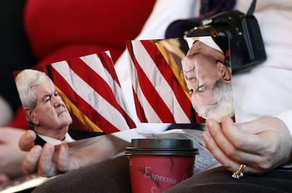 Una mujer sostiene dos postales con la cara del candidato Newt Gingrich, durante un mitín en Muscatine, Iowa.