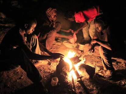 Un grupo de africanos preparan su cena en el monte Gurug&uacute;, en Marruecos, cerca de Melilla