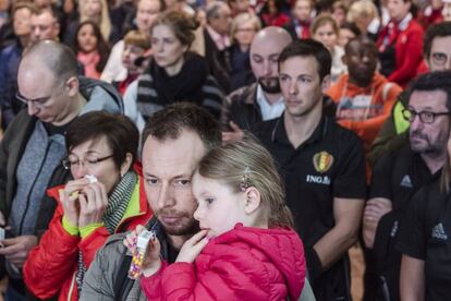 Un grupo de personas guarda un minuto de silencio durante el homenaje a las víctimas del atentado de Bruselas, en el aeropuerto de Zaventem.