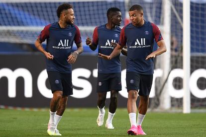 Neymar conversa com Mbappe durante treino do PSG neste sábado, em Lisboa.